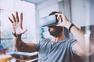 an employee of a small business having fun with a virtual reality device during his break at work which is one of the 2019 technology trends
