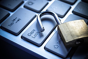 an opened lock on a keyboard to represent a data breach