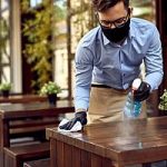 Small business owner cleaning tables