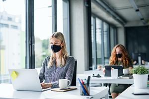 IT consultants at desks with masks 