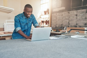 small business owner on his computer looking up compliance requirements