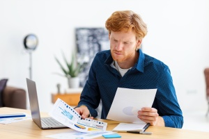 man looking at his numbers on computer