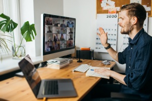 Young man having Zoom video call via a computer in the home offi