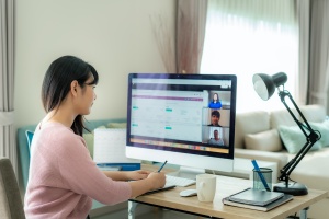 Back view of Asian business woman talking to her colleagues abou