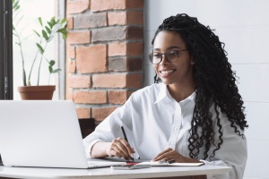 Young woman using laptop computer at office panoramic banner. St