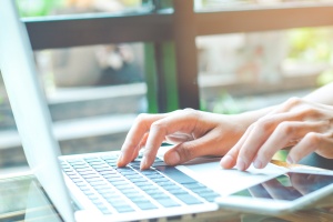 Business woman working with a laptop computer and uses a cell ph