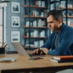 Man Working on Laptop Computer while Sitting