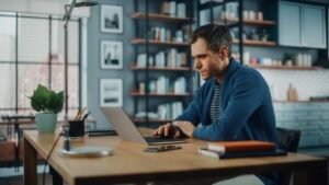 Man Working on Laptop Computer while Sitting