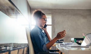 Businesswoman in conversation over phone about Cybersecurity Trends for Small Businesses