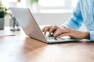 Hands of young contemporary office manager over laptop keypad during work